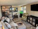 Cozy living room featuring a comfortable sectional sofa, modern shelving, and a decorative aquarium at 6524 W 14Th Ave, Lakewood, CO 80214