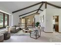 Bright living room featuring vaulted ceilings with wooden beams and plush neutral furnishings at 6844 Roaring Fork Trl, Boulder, CO 80301