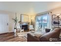 Bright living room with a fireplace, glass doors to the outside, and hardwood floors for a cozy space at 695 Manhattan Dr # 22, Boulder, CO 80303
