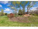 Picturesque community entrance with stone signage amidst mature trees and well-maintained landscaping at 7220 Spring Creek Cir, Niwot, CO 80503