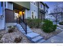 Inviting townhouse with a brick facade, complemented by manicured landscaping leading to the front door at 8482 Parkland St, Broomfield, CO 80021