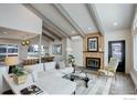 Open-concept living room featuring a fireplace, exposed beams, and hardwood floors flowing into the kitchen and dining area at 1048 Westview Dr, Boulder, CO 80303