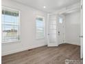 Bright entryway featuring wood-look floors, white trim, and a glass-paneled door at 1102 Ridgefield Dr, Berthoud, CO 80513