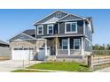 Charming two-story home with stone accents, a welcoming porch, and a well-maintained front yard at 1102 Ridgefield Dr, Berthoud, CO 80513