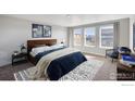 Inviting main bedroom with large windows, a comfortable bed, and stylish decor and a patterned rug at 1102 Ridgefield Dr, Berthoud, CO 80513