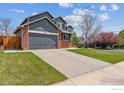 Two-story home with a brick and siding facade, featuring an attached garage and driveway at 1142 Dover Way, Broomfield, CO 80020