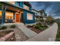 Inviting front porch with Adirondack chairs and lush landscaping leading to the main entrance at 1356 Golden Eagle Way, Louisville, CO 80027