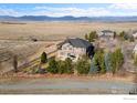 Beautiful home showcasing a spacious backyard and lush trees, all set against a backdrop of rolling hills and a mountain range at 14958 Wistera Way, Broomfield, CO 80023