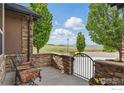 Inviting stone patio with seating, featuring views of open space and landscaping at 14958 Wistera Way, Broomfield, CO 80023