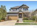 Charming two-story home featuring a manicured lawn, inviting front porch, and a two-car garage at 1833 Sweet Clover Ln, Louisville, CO 80027