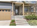 Inviting front porch featuring stylish stone accents and a cozy seating area at 1833 Sweet Clover Ln, Louisville, CO 80027