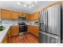 Well-lit kitchen featuring stainless steel appliances, wooden cabinets, and modern backsplash at 20336 Willowbend Ln, Parker, CO 80138