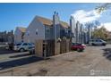 Complex featuring well-maintained grey townhomes, manicured landscaping, and convenient parking at 225 E 8Th Ave # D20, Longmont, CO 80504