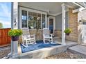 Inviting front porch with rocking chairs and stylish decor creating a cozy and welcoming entryway at 2279 Apple Tree Pl, Erie, CO 80516