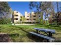 Community picnic area with modern metal picnic table and view of residential buildings and lawn at 2711 Mapleton Ave # 1, Boulder, CO 80304