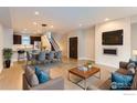 A spacious living area merges with the dining space, featuring a decorative fireplace and modern furnishings at 3150 Vallejo St, Denver, CO 80211
