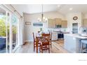 Dining area with sliding glass doors to the backyard and modern lighting fixture at 324 Spring Beauty Dr, Berthoud, CO 80513