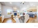 Open-concept living room with a fireplace, hardwood floors, and abundant natural light at 324 Spring Beauty Dr, Berthoud, CO 80513