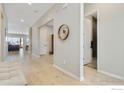 Inviting hallway with hardwood floors leading to a bathroom with dark accent tiles at 3351 Heron Lakes Pkwy, Berthoud, CO 80513