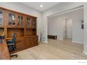 Well-lit office space with custom wood built-ins, hardwood floors and neutral paint at 3351 Heron Lakes Pkwy, Berthoud, CO 80513