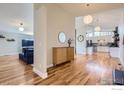 Open-concept living area featuring hardwood floors, modern lighting, and seamless flow to the kitchen at 345 S Forest St, Denver, CO 80246
