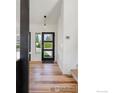 An open entryway with a high ceiling, wooden floors, and a modern door at 4223 Peach Way, Boulder, CO 80301