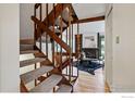 Open entryway with wood staircase and views of the stylish living room with fireplace at 4604 Greenbriar Ct, Boulder, CO 80305