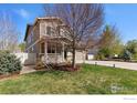 Charming two-story home with a welcoming front porch, well-maintained lawn, and mature trees at 4737 Sandy Ridge Ave, Firestone, CO 80504