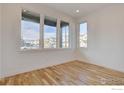 Bright, naturally lit sitting room with beautiful hardwood floors and large windows providing street views at 499 Muirfield Cir, Louisville, CO 80027
