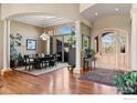Elegant entryway with grand columns, hardwood floors, and striking natural light and front door at 5288 Waterstone Dr, Boulder, CO 80301