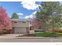Charming two-story home with manicured lawn, mature trees and an attached two-car garage at 586 Aztec Dr, Boulder, CO 80303