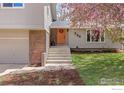 Inviting front entrance with an orange door, well-manicured lawn, and beautiful landscaping at 586 Aztec Dr, Boulder, CO 80303