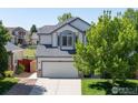 Beautiful exterior of a two-story home with a well-maintained lawn, attached garage, and mature trees at 5912 Thistle Ridge Ave, Firestone, CO 80504
