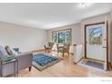 Bright living room featuring hardwood floors, comfortable seating, a window, and a welcoming front entrance at 601 Candice Ct, Berthoud, CO 80513