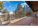Spacious wood deck with steel railing offers scenic views of the surrounding trees at 74 Sky Trail Rd, Boulder, CO 80302