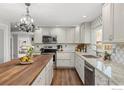 White kitchen with granite countertops, stainless steel appliances, and a charming island at 8138 Captains Ln, Longmont, CO 80504