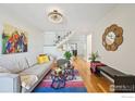 Inviting living room featuring hardwood floors, a stylish rug, and neutral-toned furniture at 951 Vetch Cir, Lafayette, CO 80026