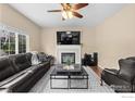Cozy living room boasts a fireplace, TV, and a comfortable leather sofa at 956 Shavano Peak Dr, Superior, CO 80027