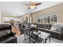 Bright living room featuring a leather sectional, ceiling fan, and large window views at 956 Shavano Peak Dr, Superior, CO 80027