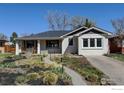 Inviting brick home with front porch, chairs, and landscaped garden with walkway at 1150 Eudora St, Denver, CO 80220