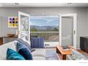 Bright living room with stylish furniture, hardwood floors, and sliding glass doors open to outdoor deck and mountain view at 1247 Westview Dr, Boulder, CO 80303
