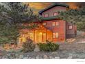 Charming exterior showcasing the log accents, covered porch, and mature landscaping at 1319 County Road 83, Boulder, CO 80302