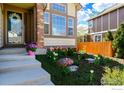 Charming home entrance with decorative flowerbed and brick-accented pillars at 1320 Indian Paintbrush Ln, Longmont, CO 80503