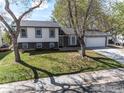 Inviting two-story home with a well-manicured lawn, mature trees, and a two-car garage at 162 Monarch St, Louisville, CO 80027