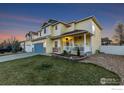 A charming two-story home featuring a cozy front porch and well-maintained lawn at 16315 9Th St, Mead, CO 80542