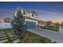 Two-story home with a manicured lawn, a two-car garage and mature tree at 16315 9Th St, Mead, CO 80542