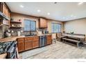 Kitchen features custom wood cabinets, stainless steel appliances, and a dining area at 173 Jackson Ave, Firestone, CO 80520