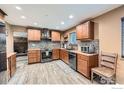 Kitchen features custom wood cabinets, stainless steel appliances, and tile backsplash at 173 Jackson Ave, Firestone, CO 80520