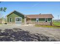 Well-maintained single story home featuring stone accents, a gravel driveway and green lawn at 205 S County Road 23, Berthoud, CO 80513