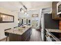 Open kitchen features stainless steel appliances, island with granite countertops, and seamless access to living area at 2201 Pearl St # 321, Boulder, CO 80302